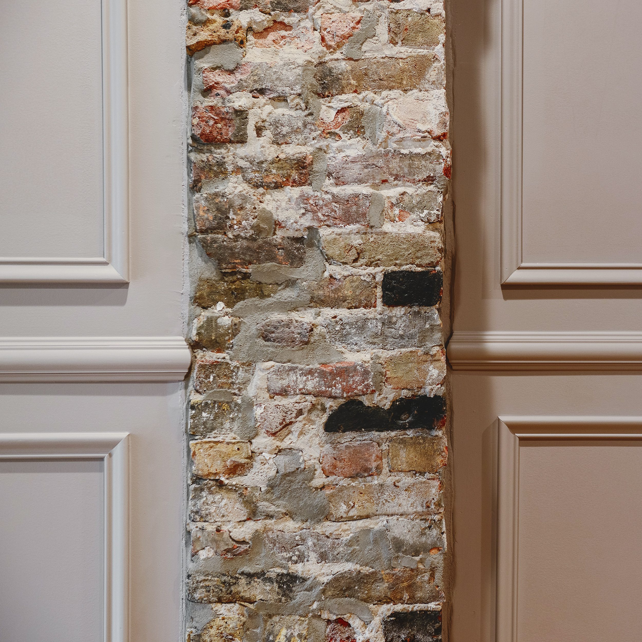 Detail of exposed brick chimney in mauve dining room | via Yellow Brick Home