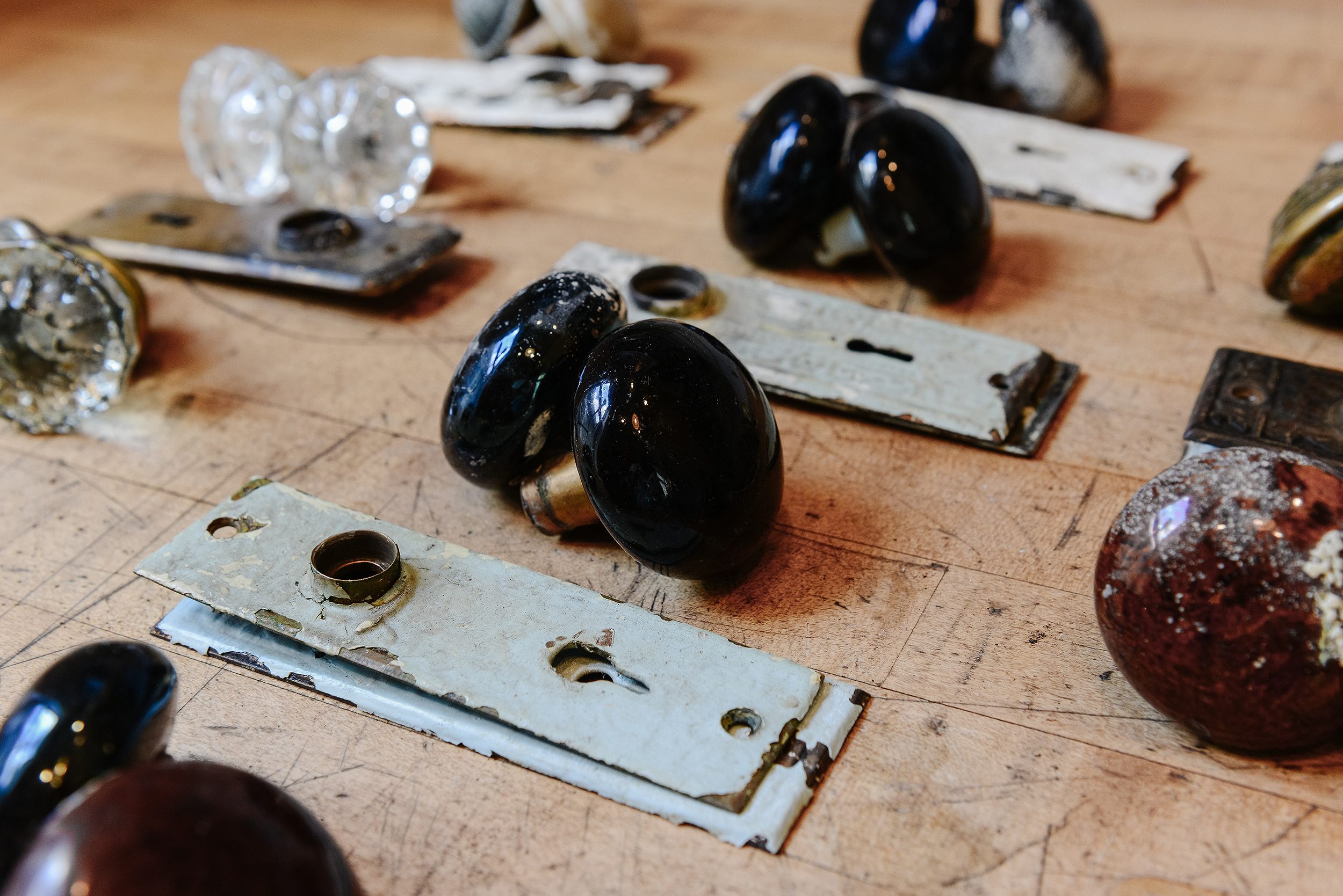 All the old hardware lined up, waiting to be boiled in the crockpot to remove decades of yucky paint | via Yellow Brick Home