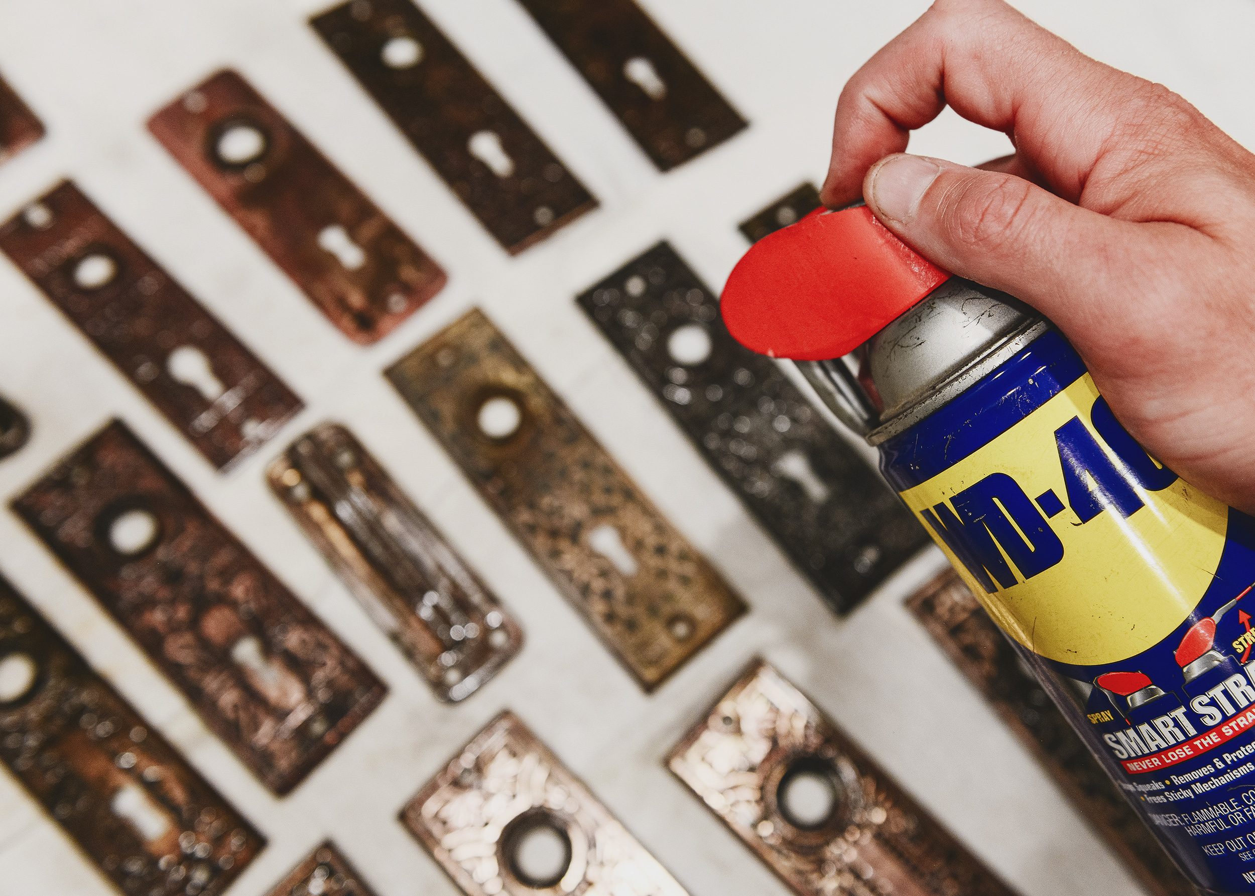 Lighting mist the hardware with WD-40 to prevent the hardware from rusting after using the boiling method | via Yellow Brick Home