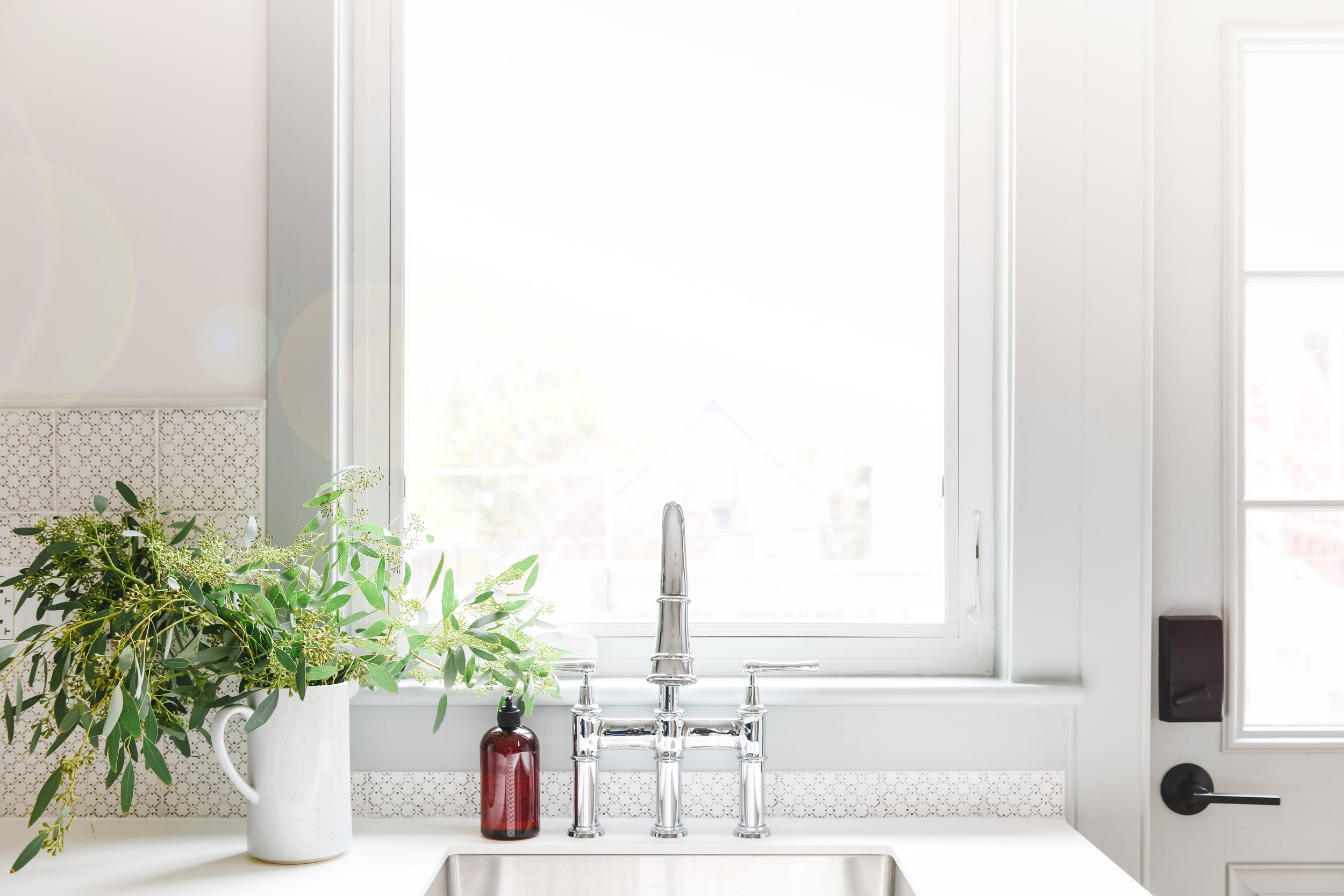 polished chrome bridge faucet, overlooking a window to a Chicago backyard | via Yellow Brick Home
