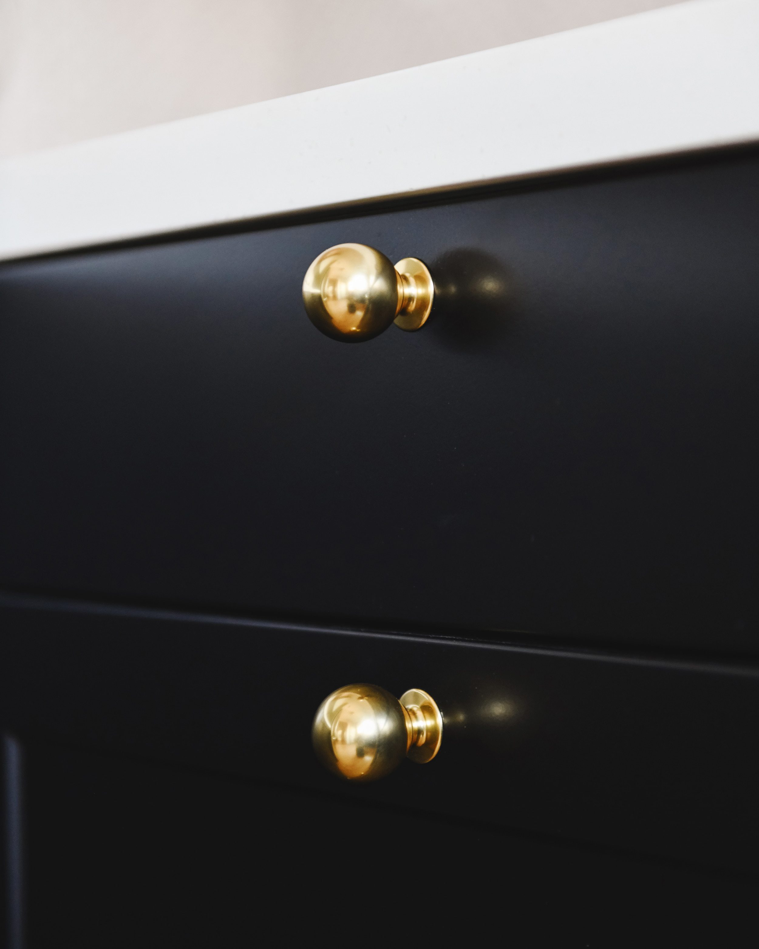 Brass ball knob on a black cabinet door | via Yellow Brick Home