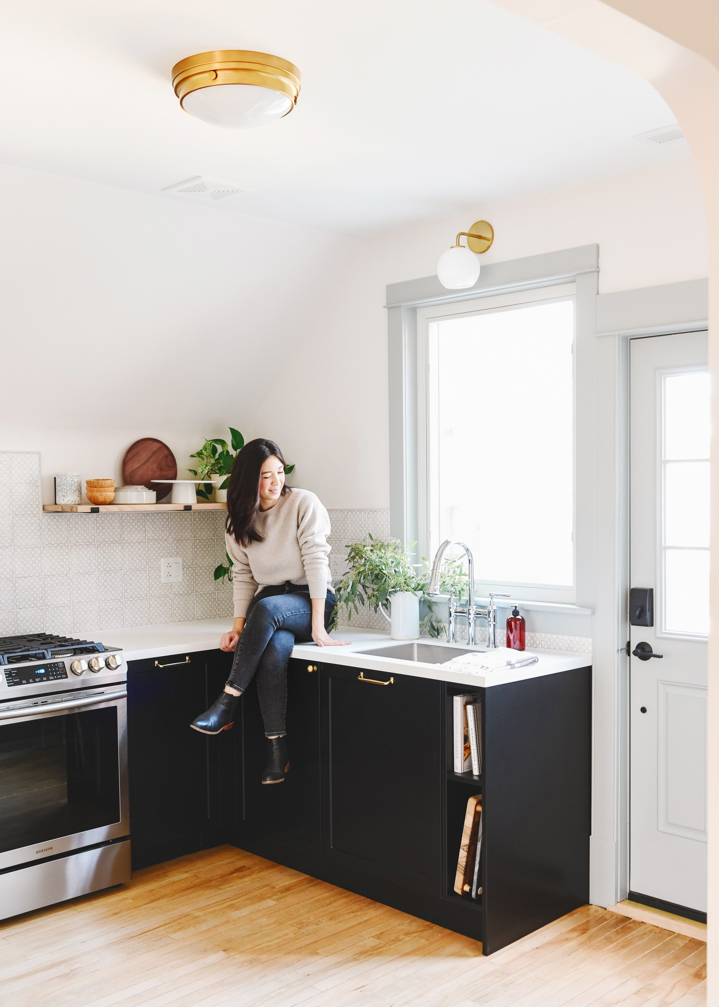 Kim in the Unit 2 kitchen, sitting on the countertop | via Yellow Brick Home