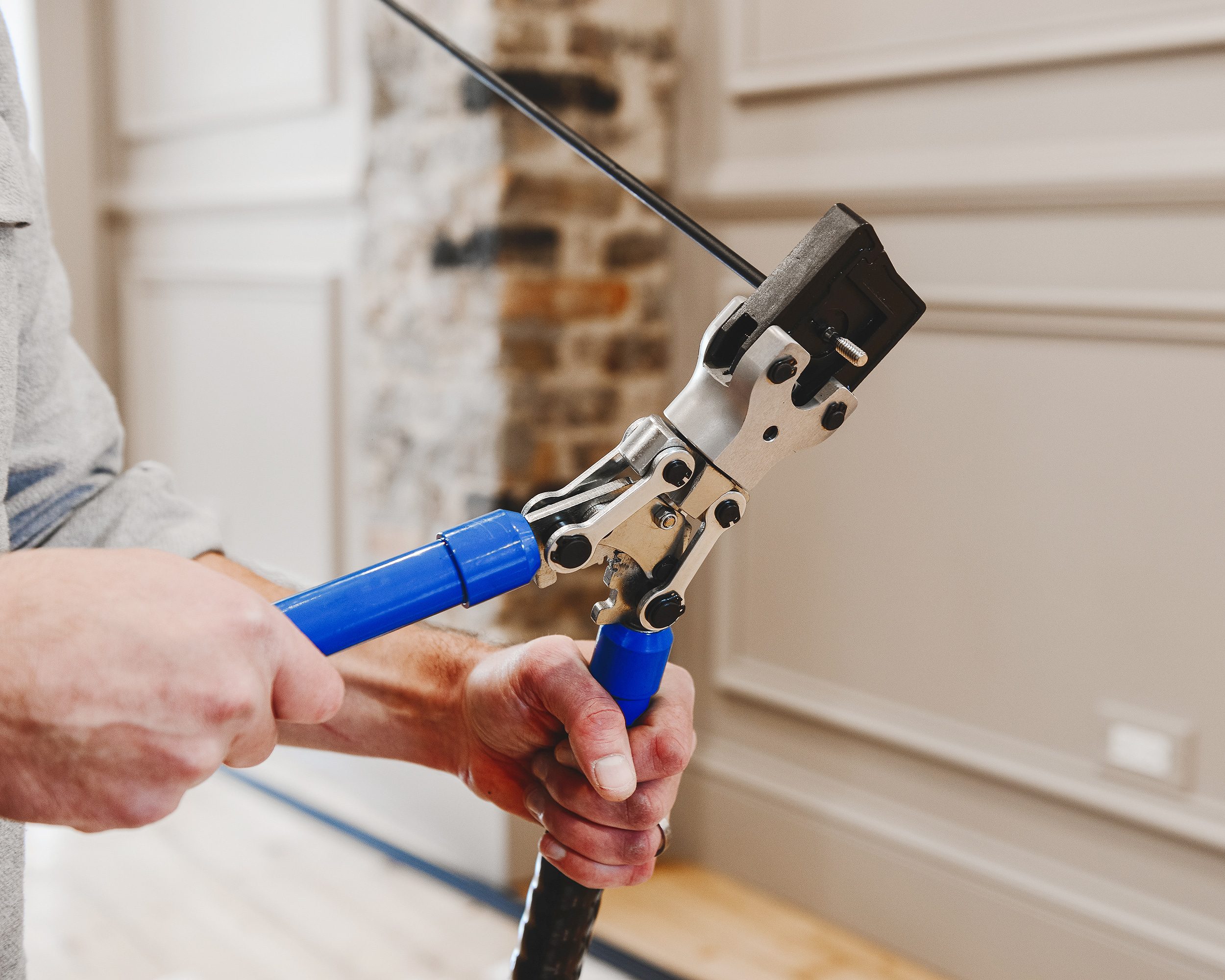 A crimper tool is used to install fasteners onto the rod components of a kitchen railing. | via Yellow Brick Home