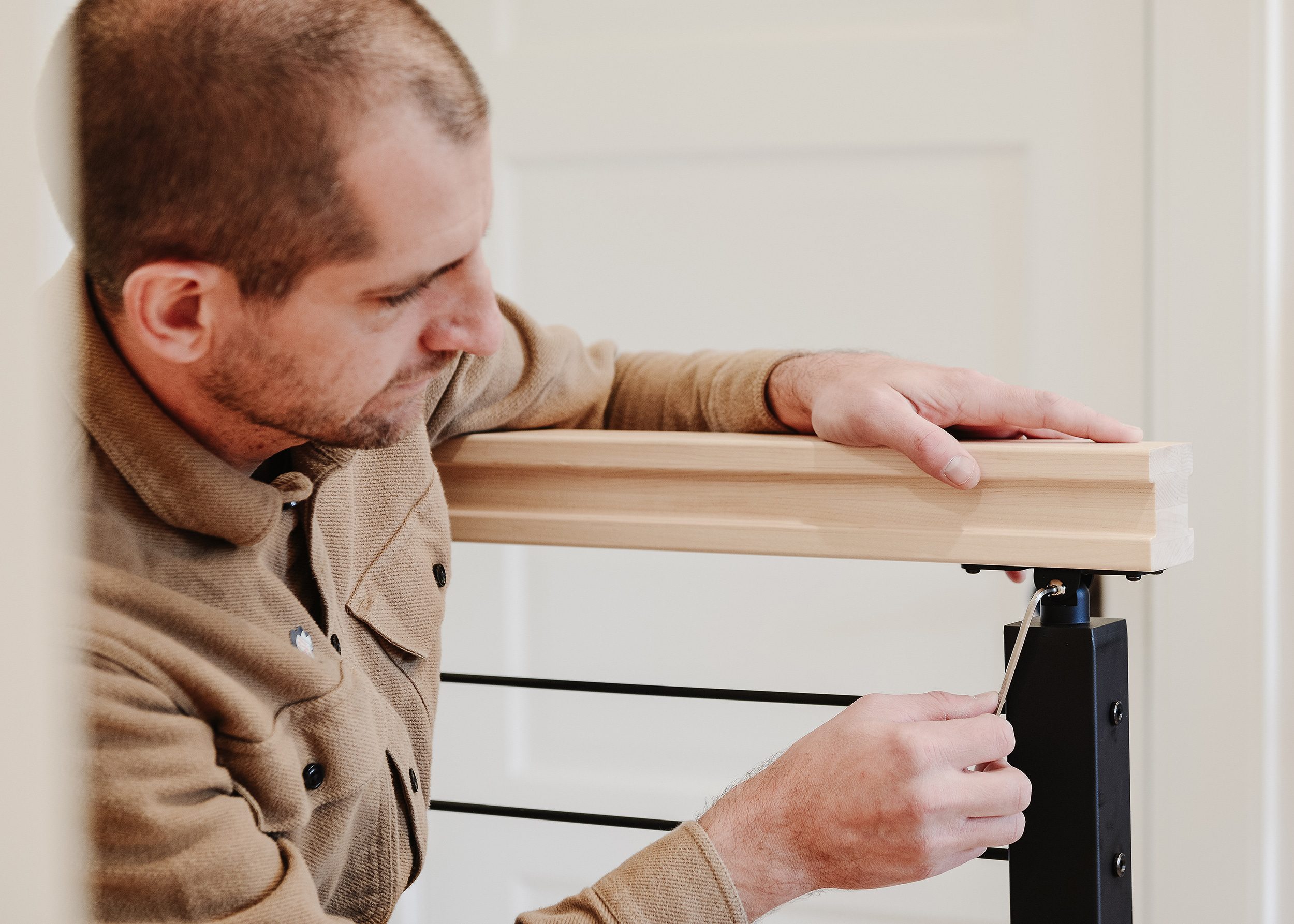 Scott uses a hex key to attach a handrail to the top of a newly installed railing. | via Yellow Brick Home 