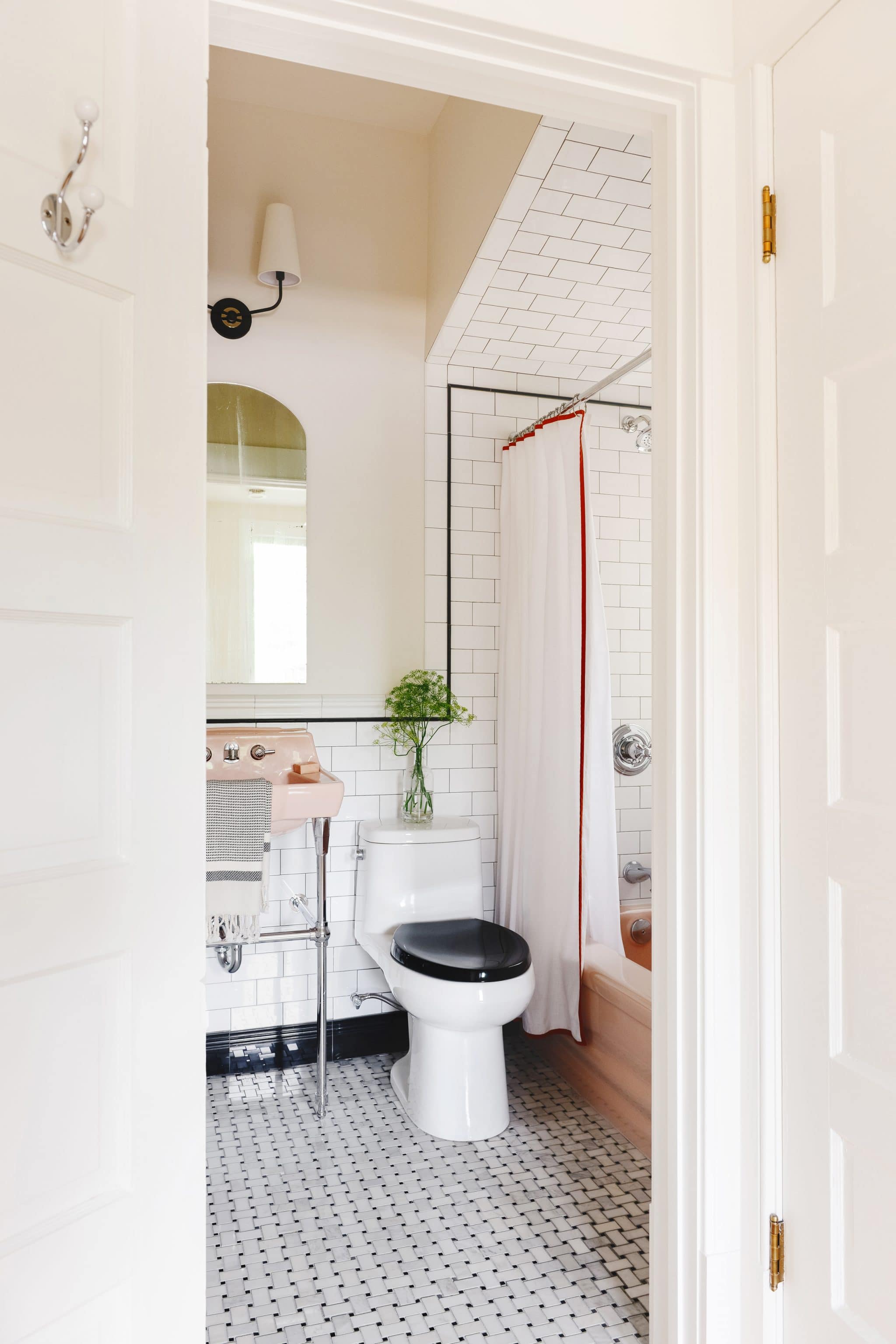A classic pink bathroom, updated with subway tile and black pencil liner | via Yellow Brick Home