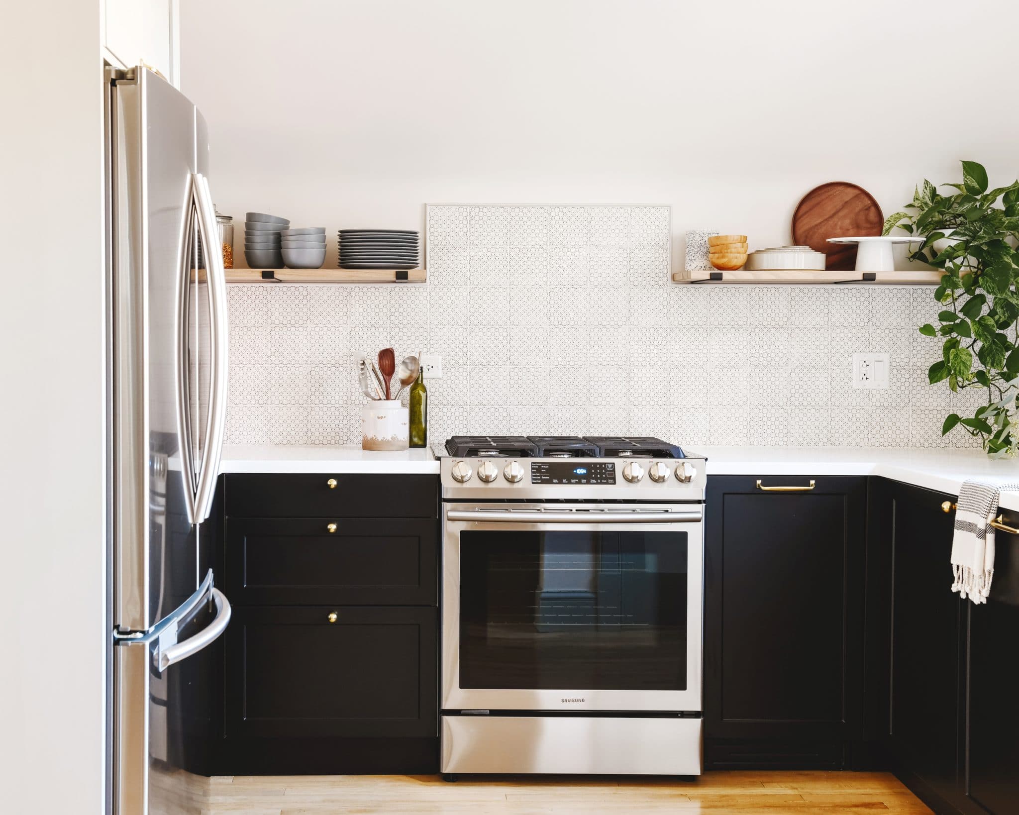 Black kitchen cabinets, white countertop and patterned tile backsplash | via Yellow Brick Home