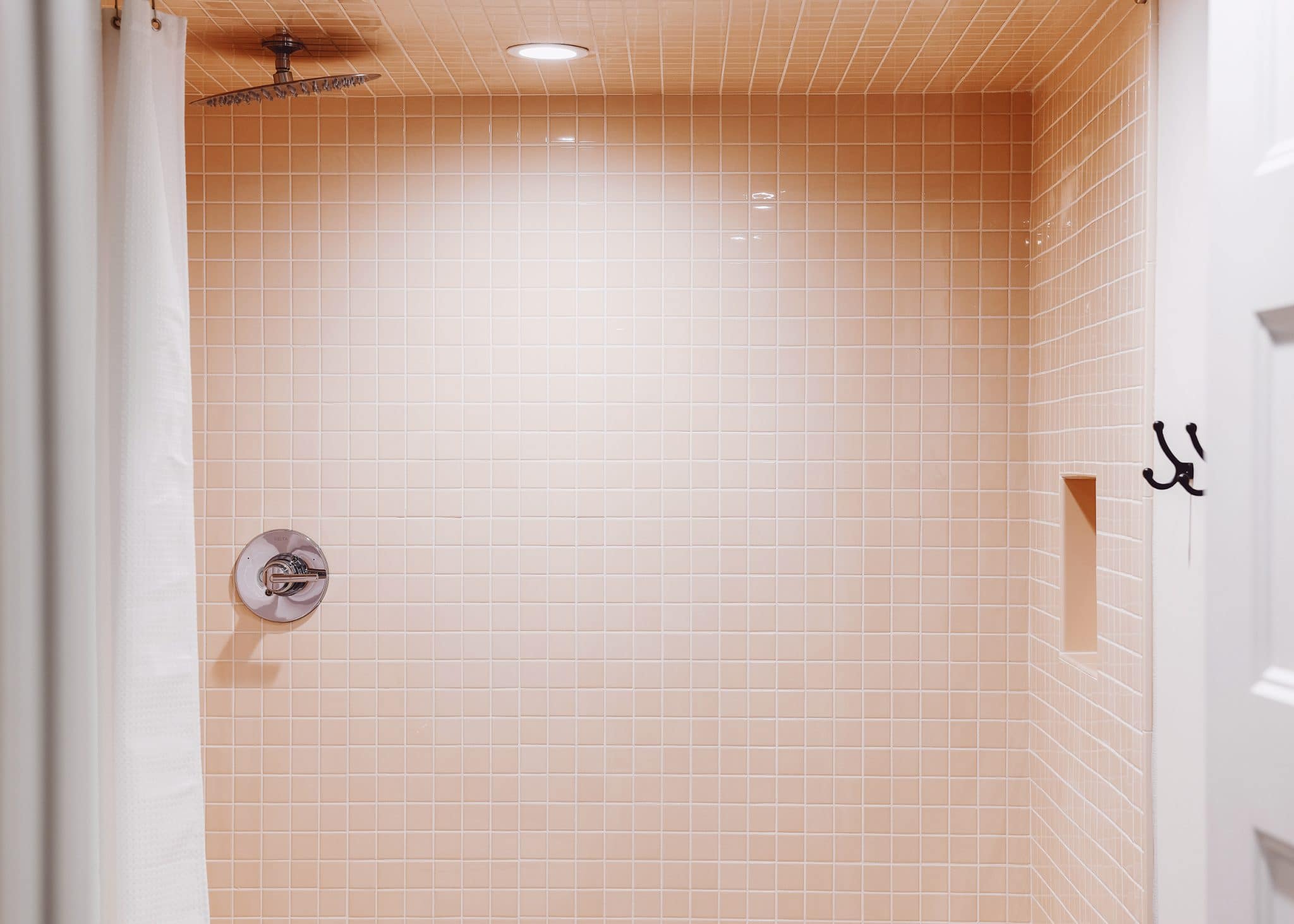 Peach mini square tile in a standing shower enclosure | via Yellow Brick Home