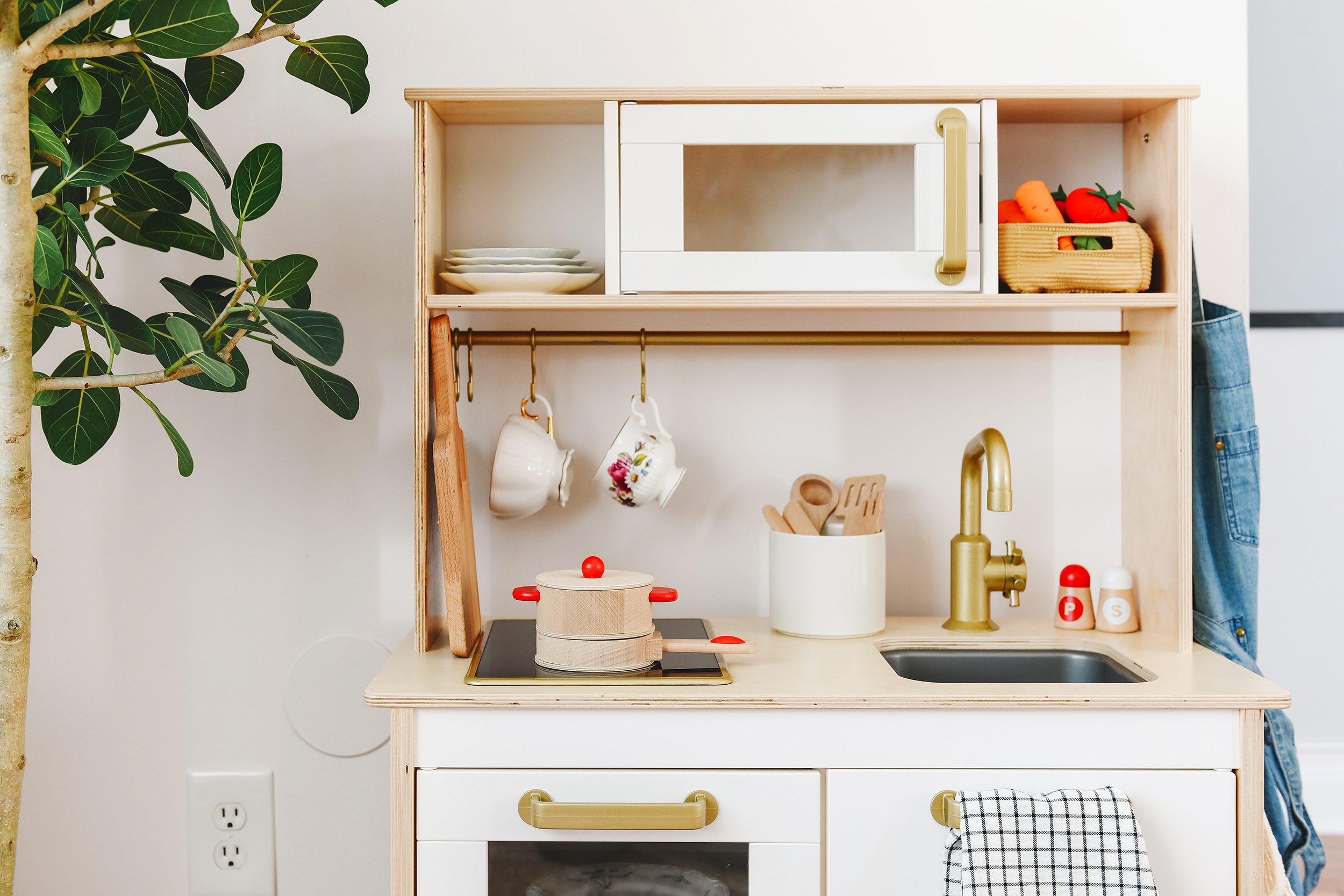 Tips for Stocking Your Play Kitchen + 36 of the Cutest Accessories! | A corner of Lucy's playroom showing a close up of her IKEA DUKTIG play kitchen | via Yellow Brick Home