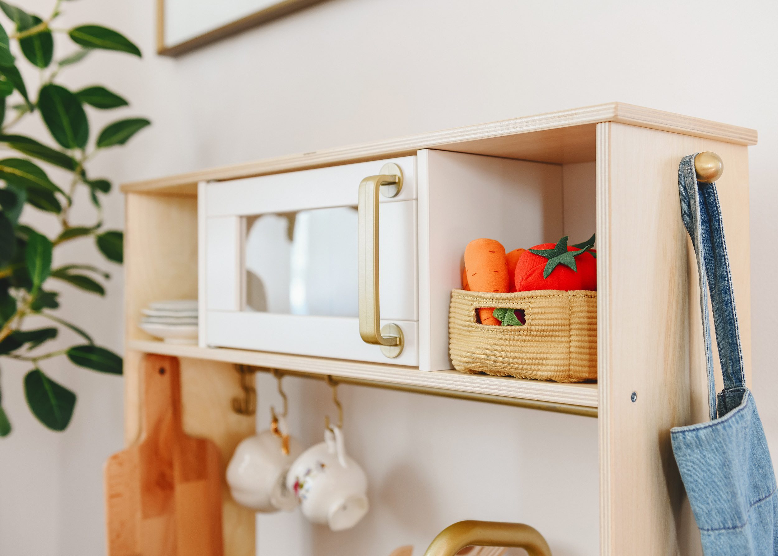 Tips for Stocking Your Play Kitchen + 36 of the Cutest Accessories! | A corner of Lucy's playroom showing a close up of plush veggies in her play kitchen | via Yellow Brick Home