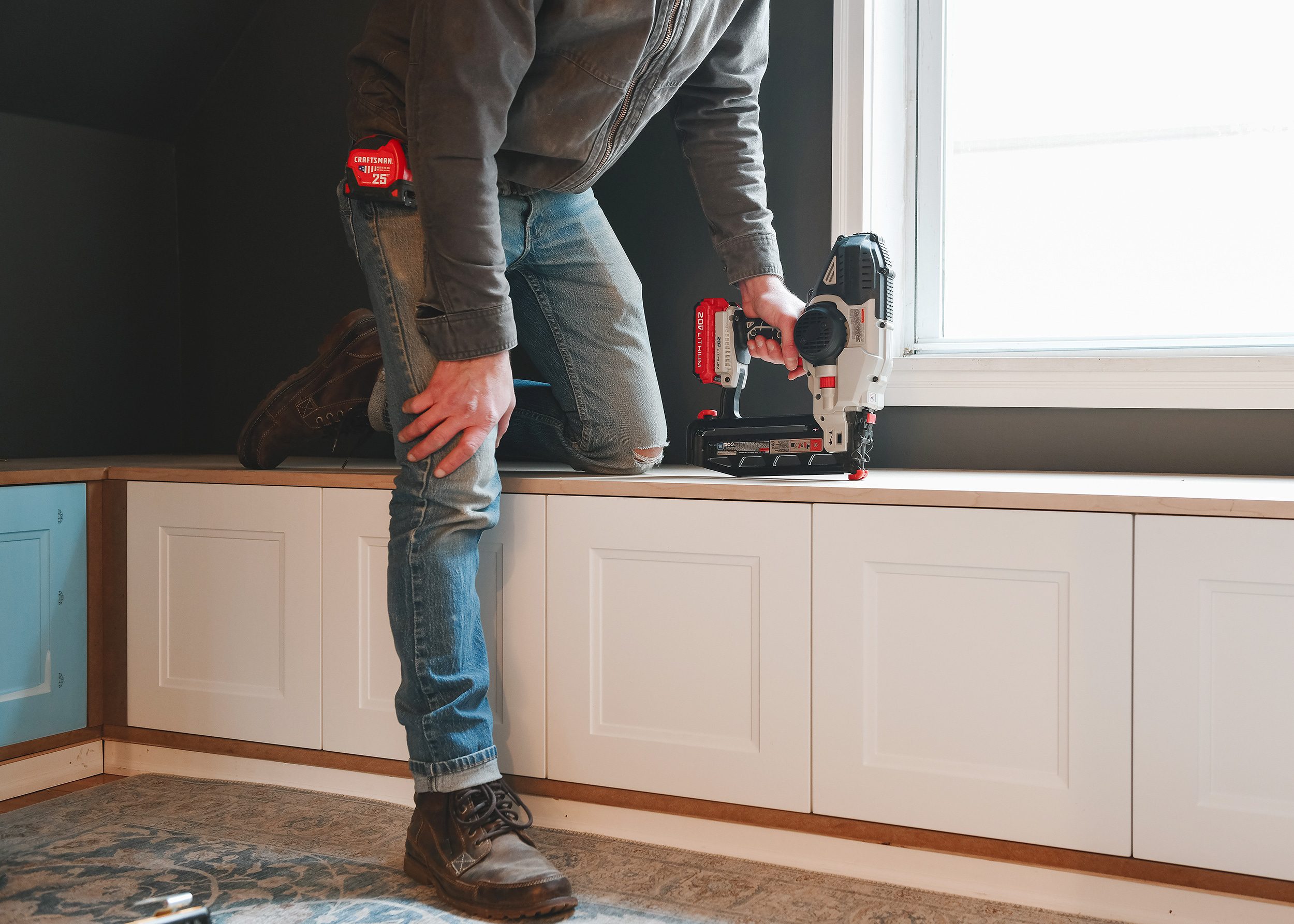 Scott uses the finish nailer to attach the cabinet top to the cabints // via Yellow Brick Home