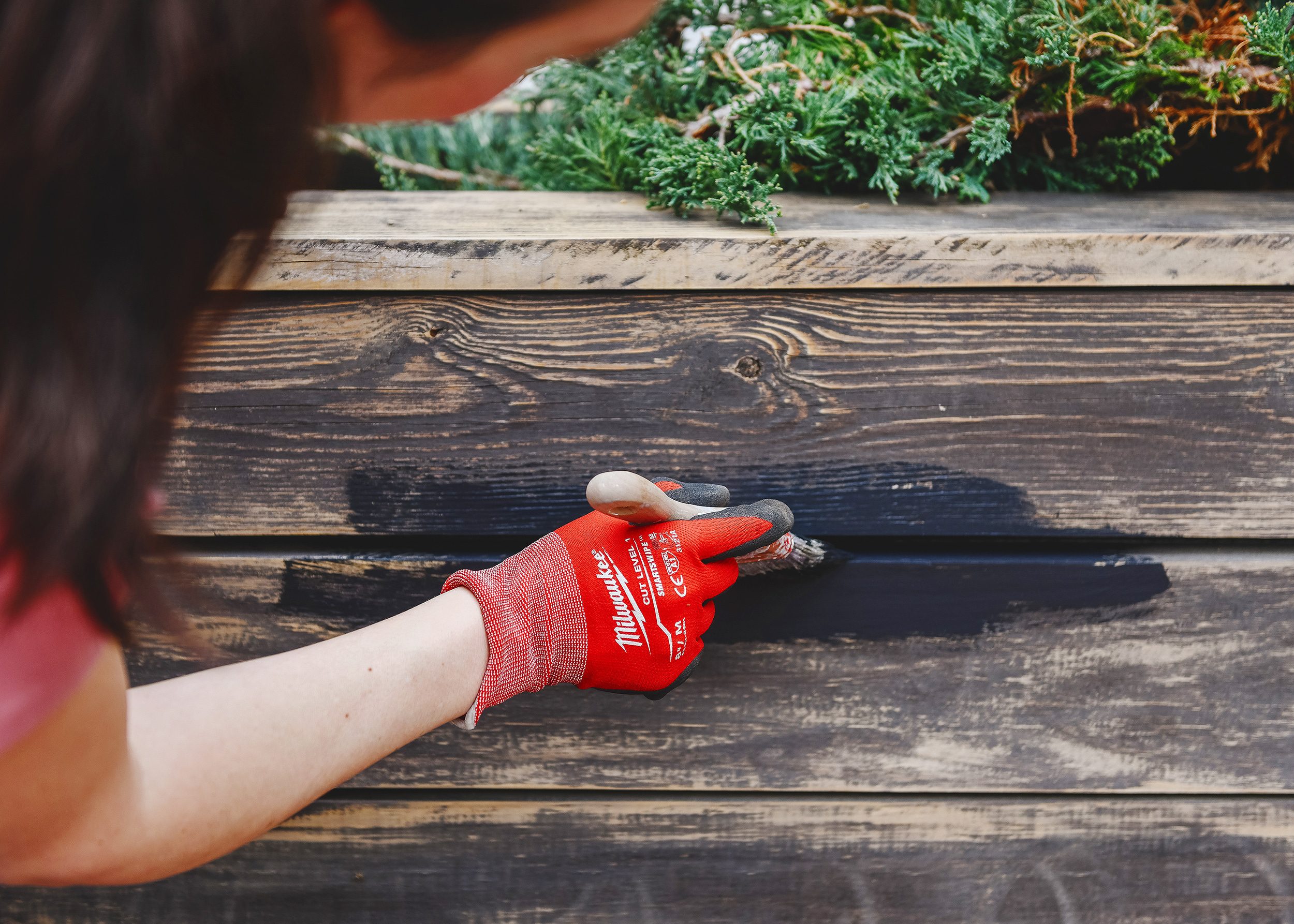 Kim applies Valspar Darkest Night solid stain to the planter boxes with an angled brush // via Yellow Brick Home. 