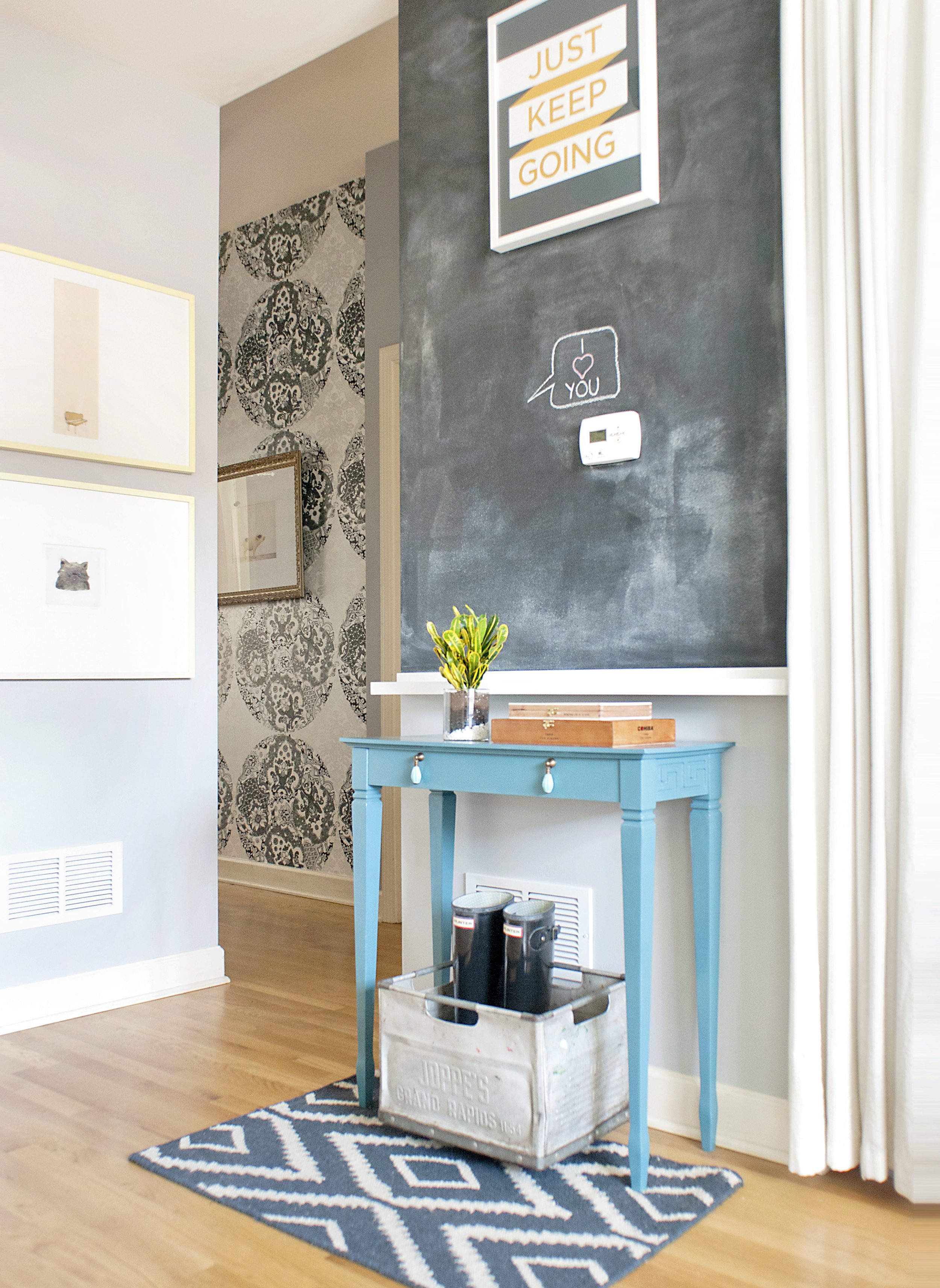 Entryway with small blue console table and chalkboard wall | via Yellow Brick Home