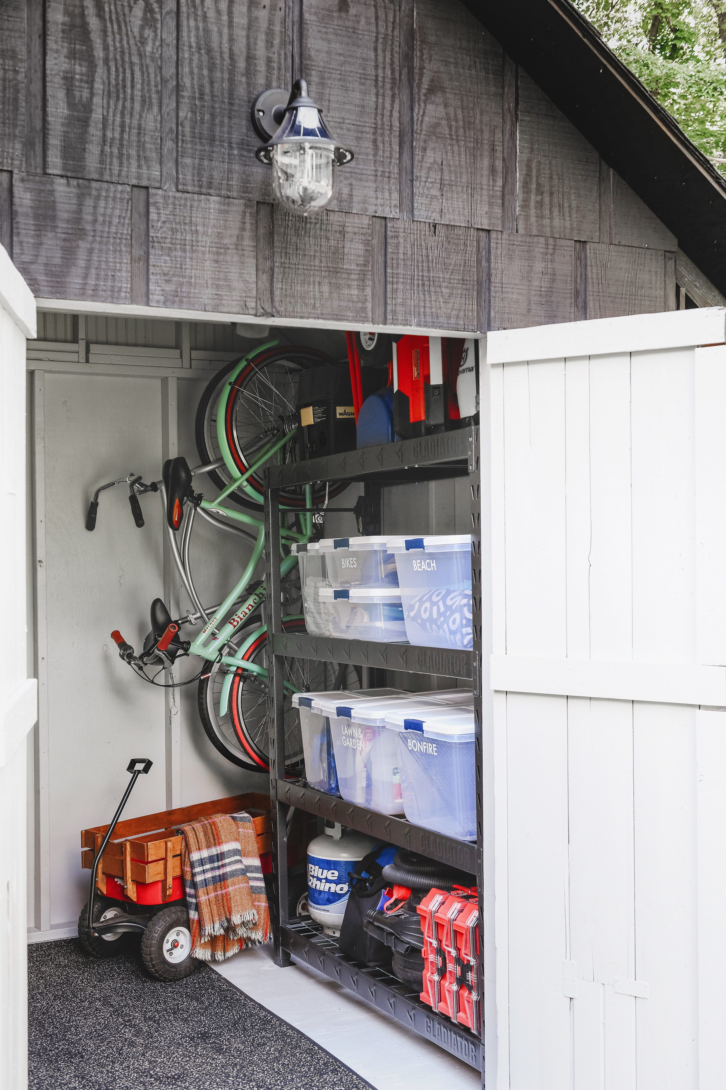 An organized shed with a pegboard wall, strong shelving, utility bins and solar lighting! via Yellow Brick Home