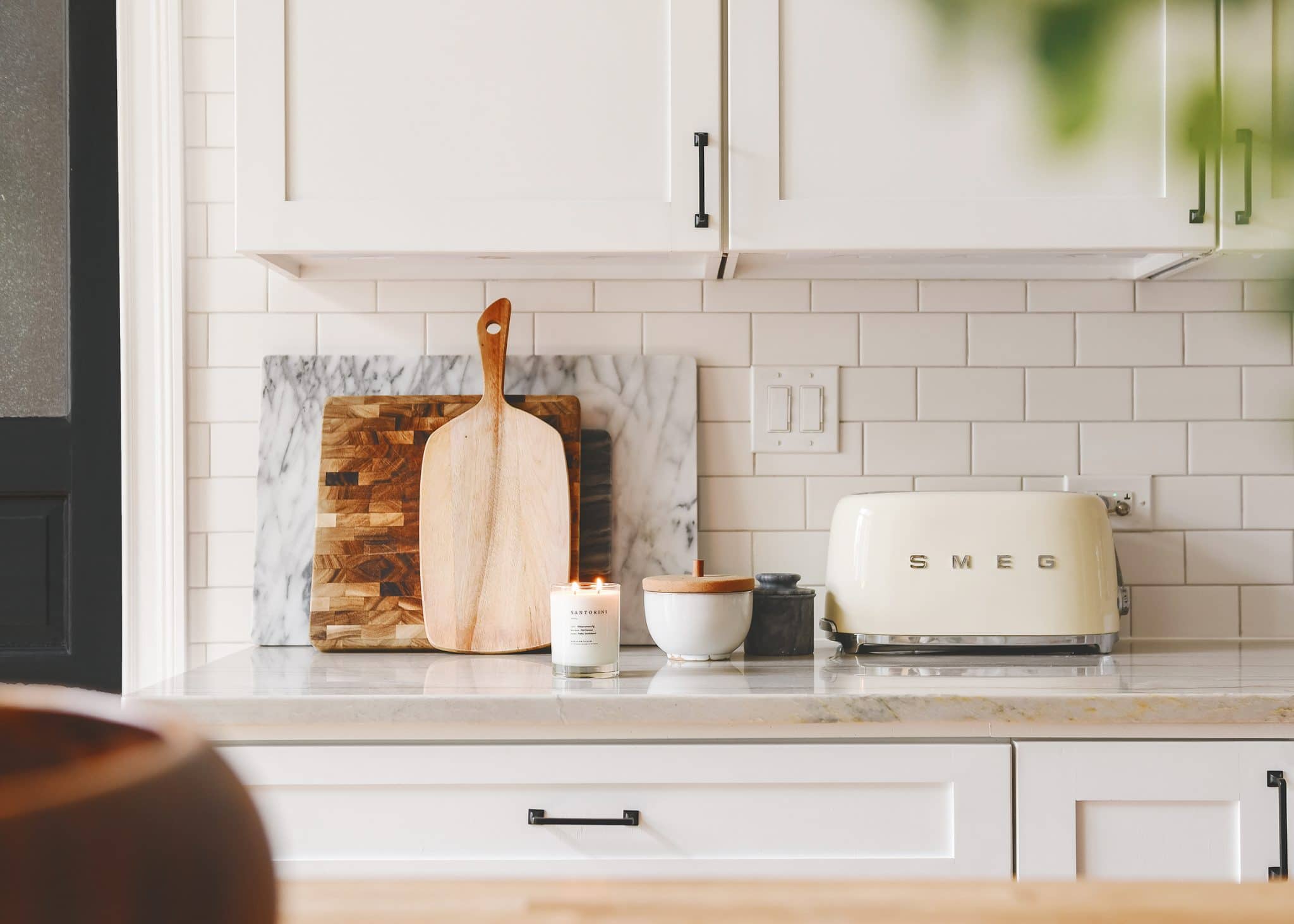 A kitchen countertop with a candle burning next to the toaster | the scents that fill our home, via Yellow Brick Home