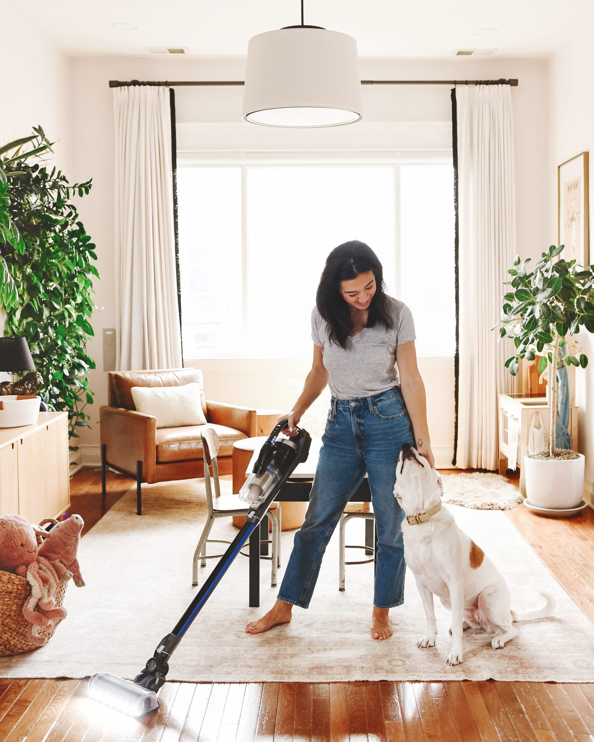 Kim uses the BISSELL® ICONpet® EDGE to vacuum the family while Catfish looks on in admiration. 
