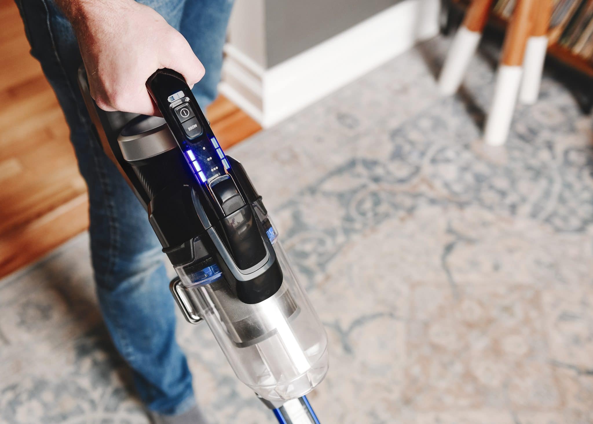 Scott uses the BISSELL® ICONpet® EDGE vacuum too clean the rug in the snug. 