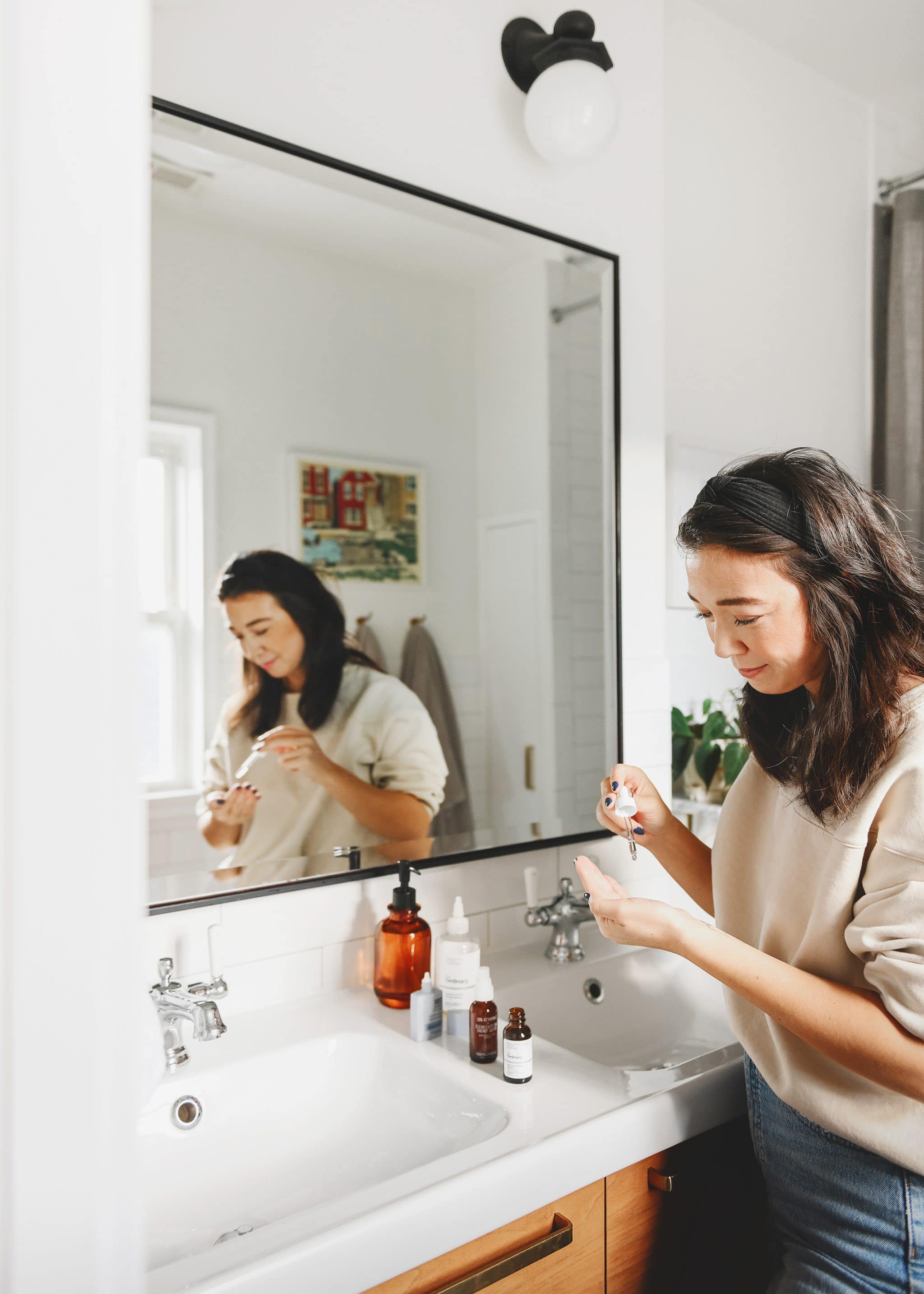 Kim adding squalane to vitamin C as a part of the morning skincare routine | My Skincare Routine + Essential Products via Yellow Brick Home