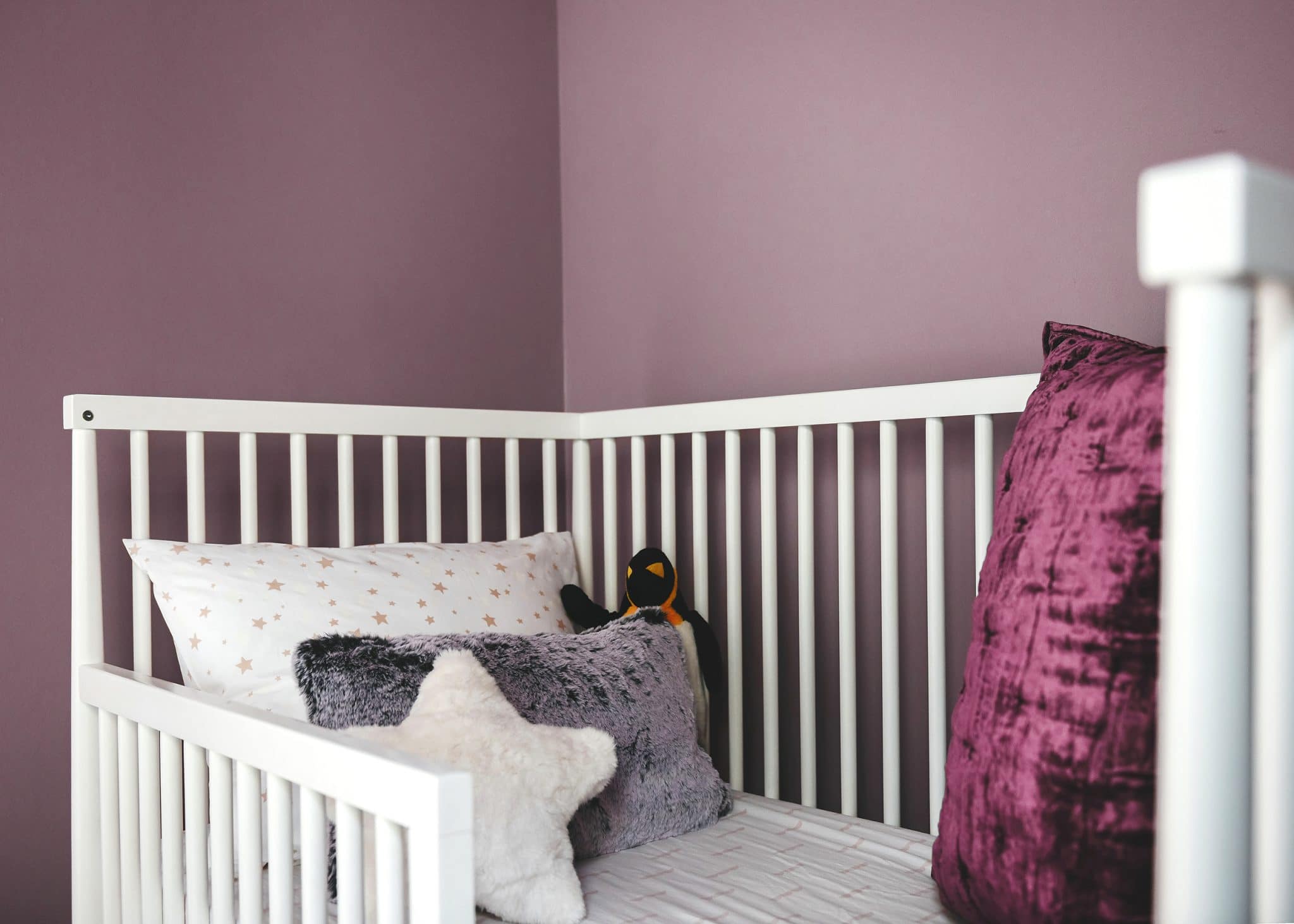 A close-up of Lucy's bed with purple walls | color is Valspar Mellow Mauve 1004-7C | via Yellow Brick Home