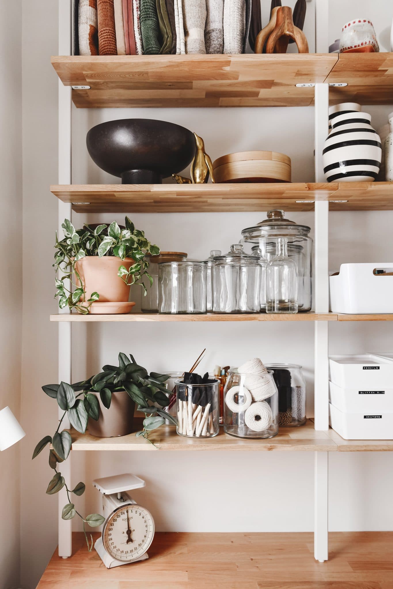 Vases, lighting and planters share space with art supply bins on the Climb shelving. 