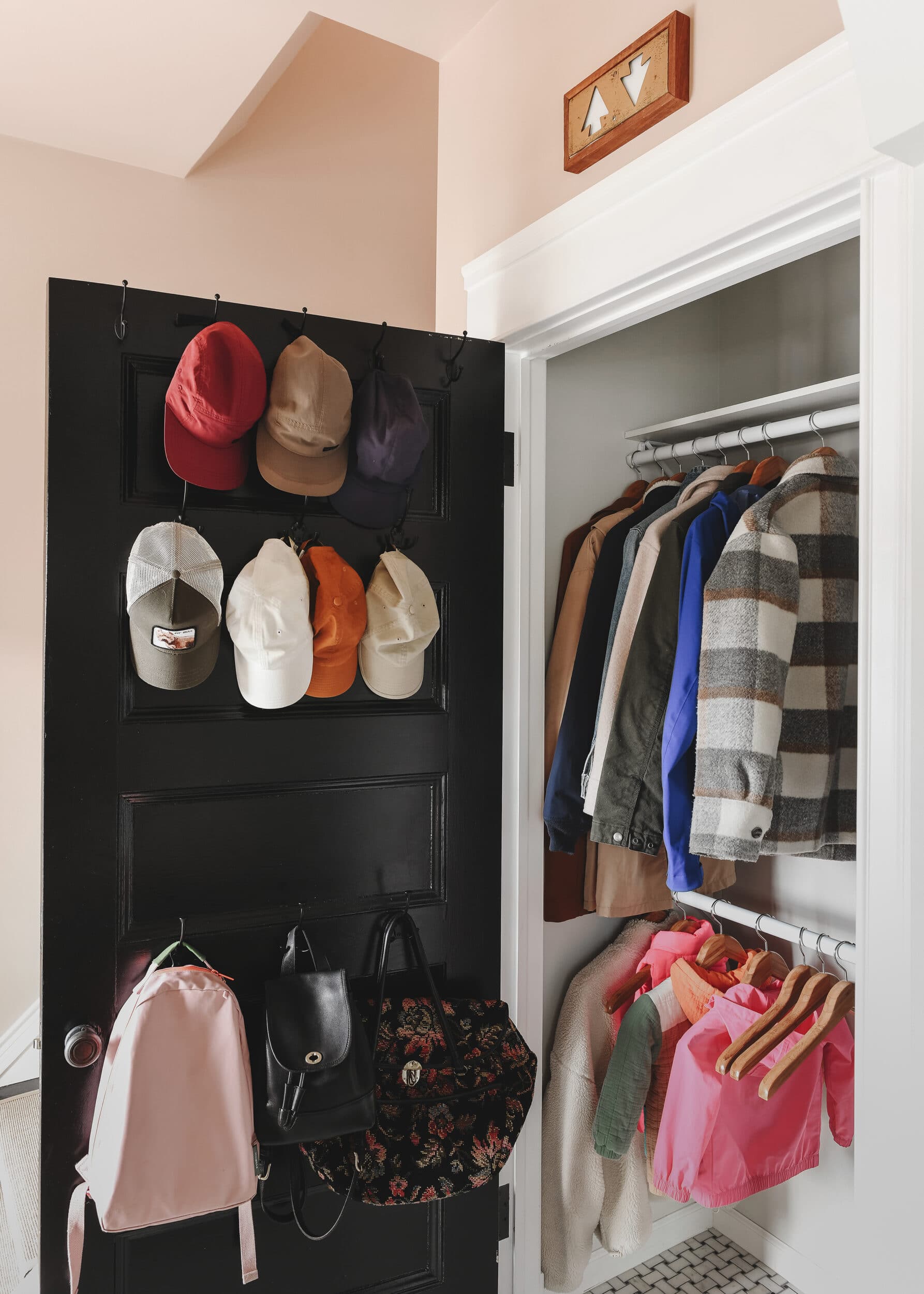 Our newly organized hall closet features two clothing rails and vertical shelving along the right side. Don't forget the hooks! 