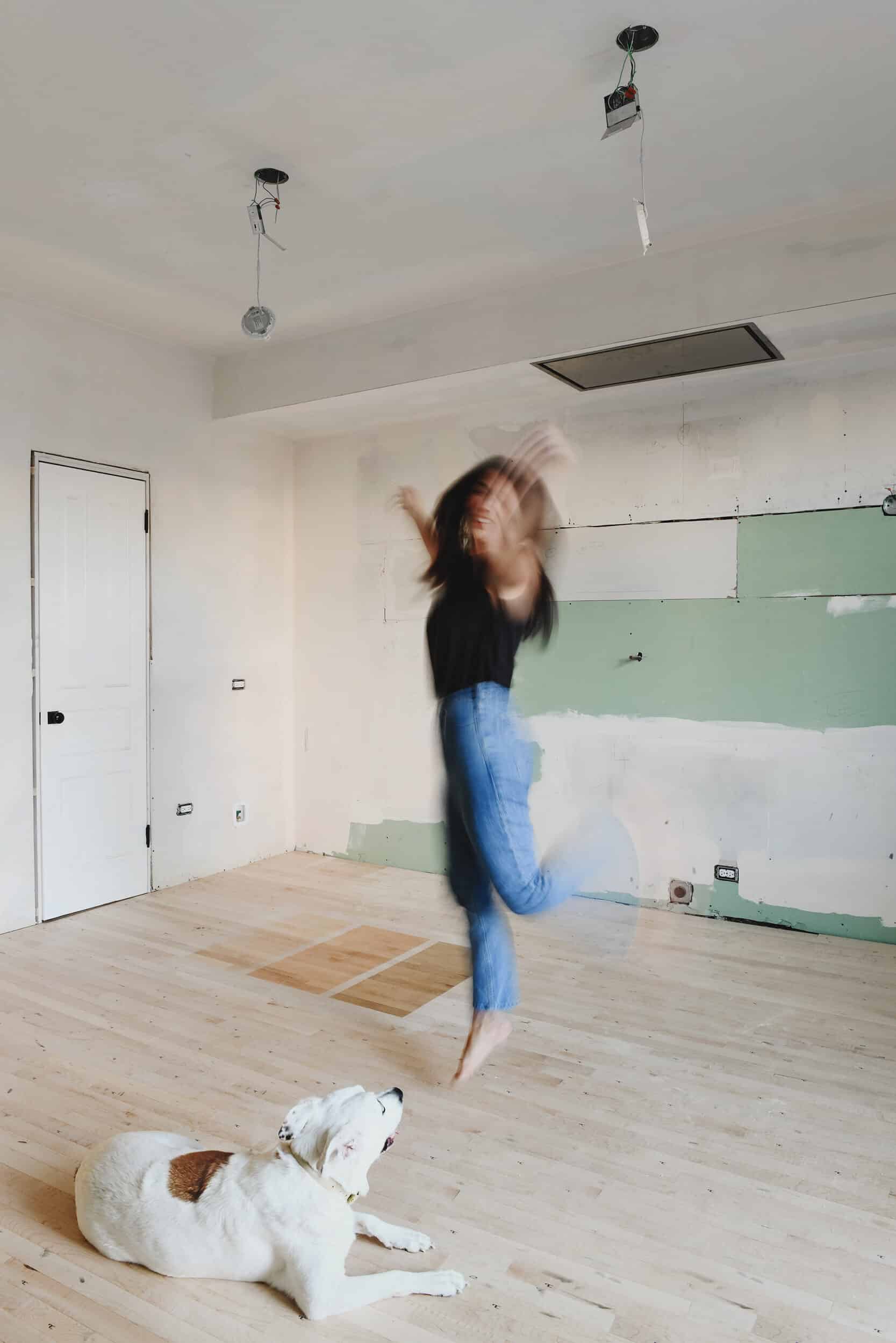 Kim dancing on our newly installed maple floors in the kitchen | via Yellow Brick Home