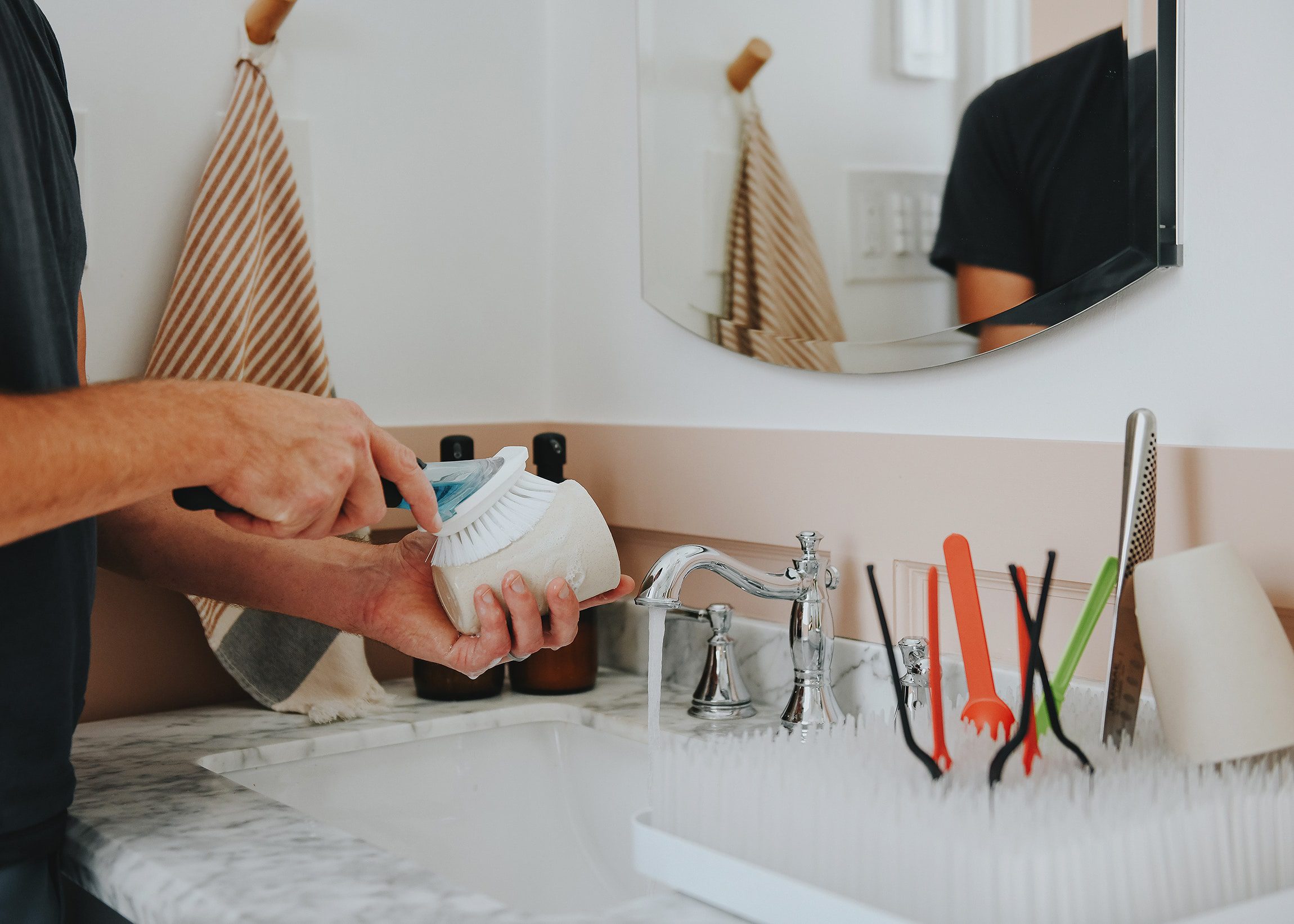 Cleaning dishes and reusable plastic serveware at the bathroom sink | How we've gotten by for 2 months without a working kitchen | via Yellow Brick Home