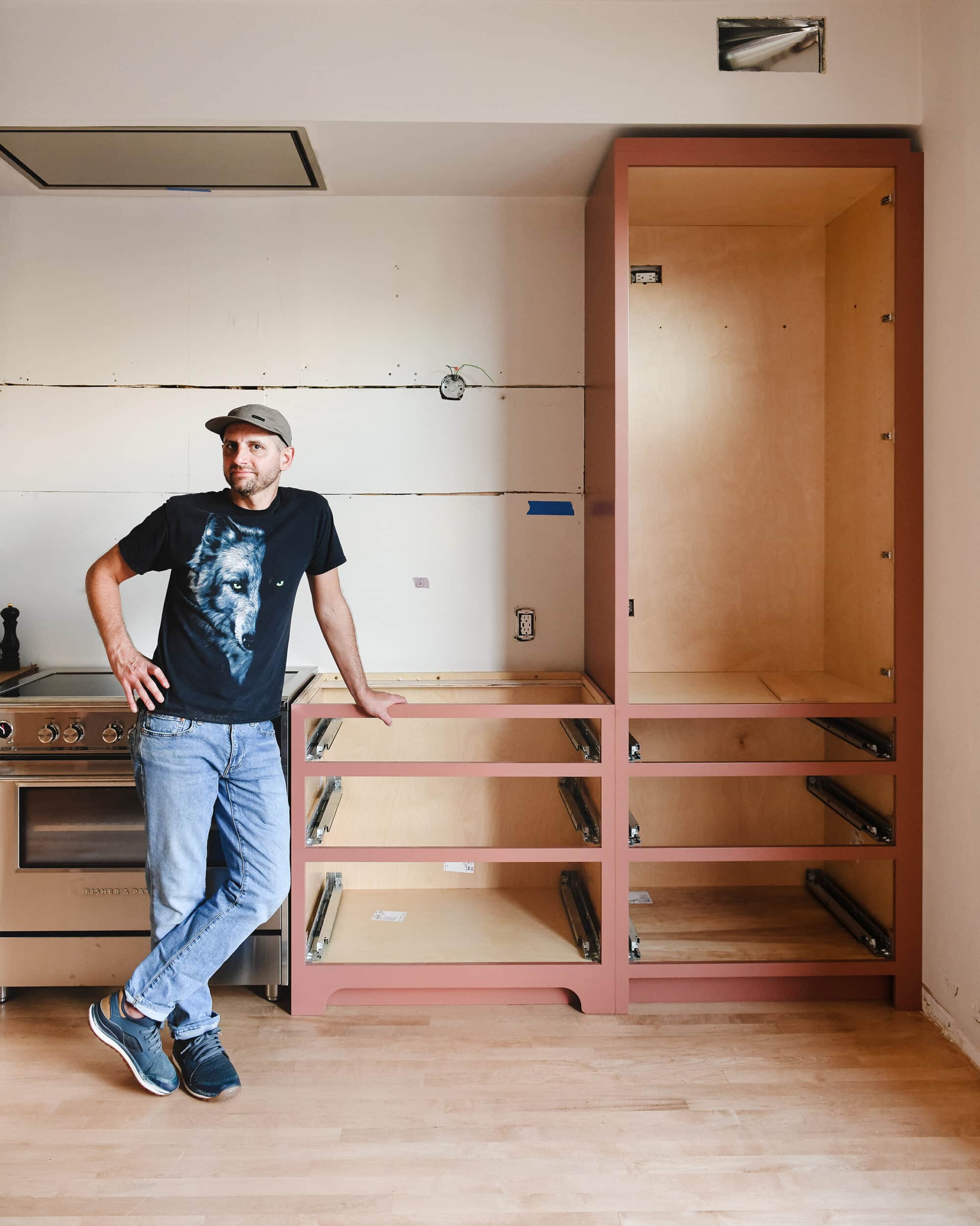 Scott stands in front of the first finished wall of cabinets // via Yellow Brick Home