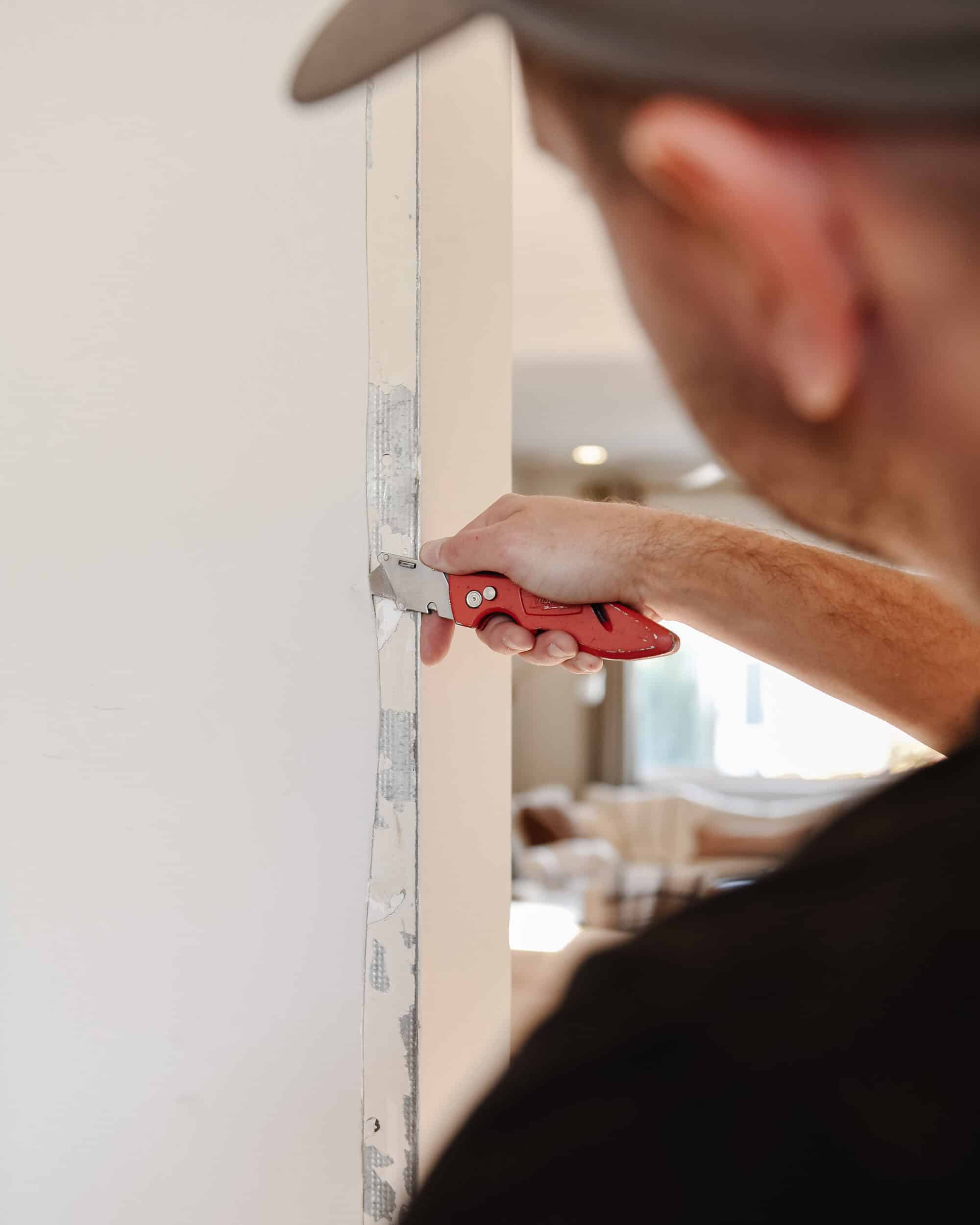 Scott removes excess drywall mud from the door opening // via yellow brick home