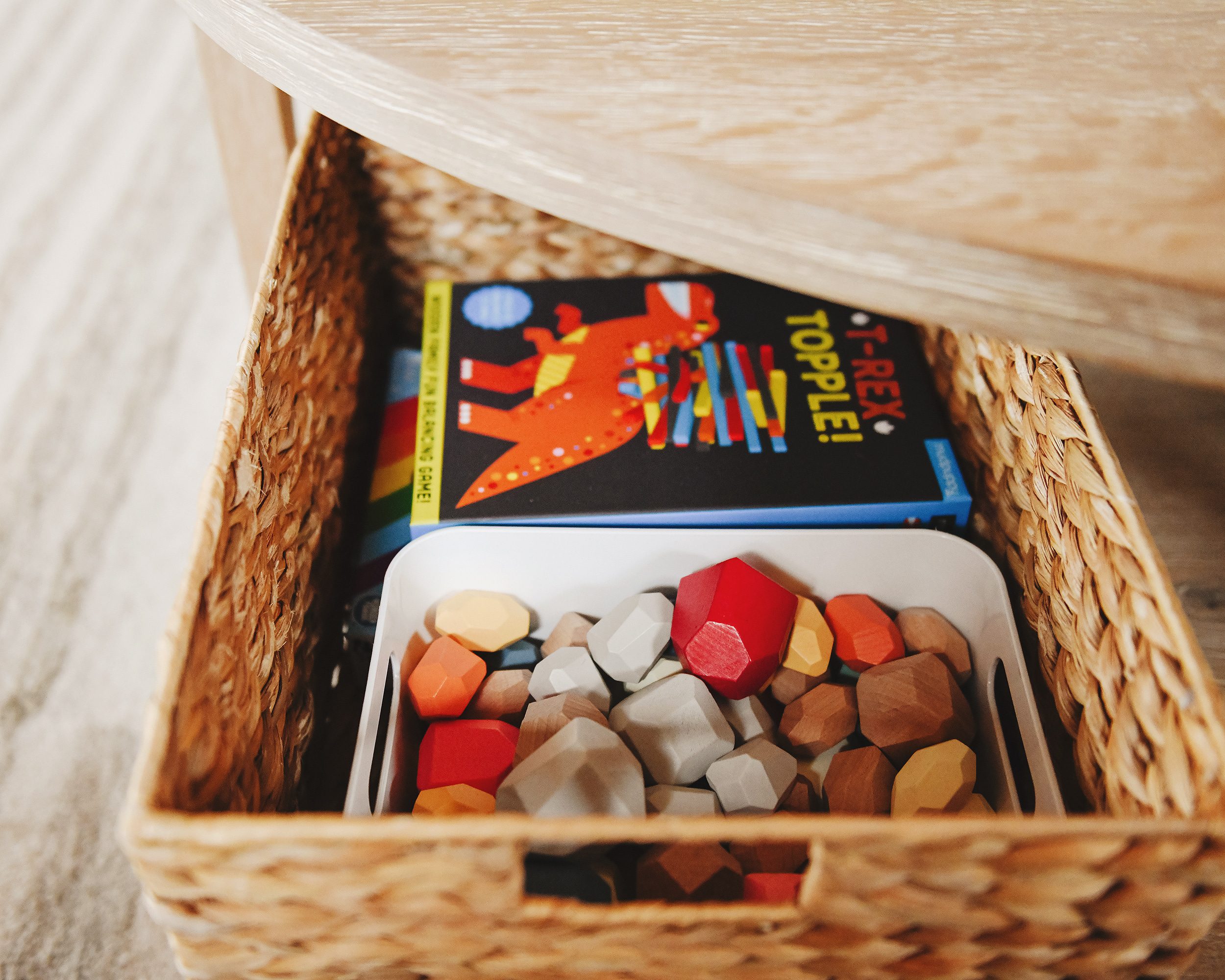 Detail showing toys tucked into basket, being stored in the coffee table | via Yellow Brick Home