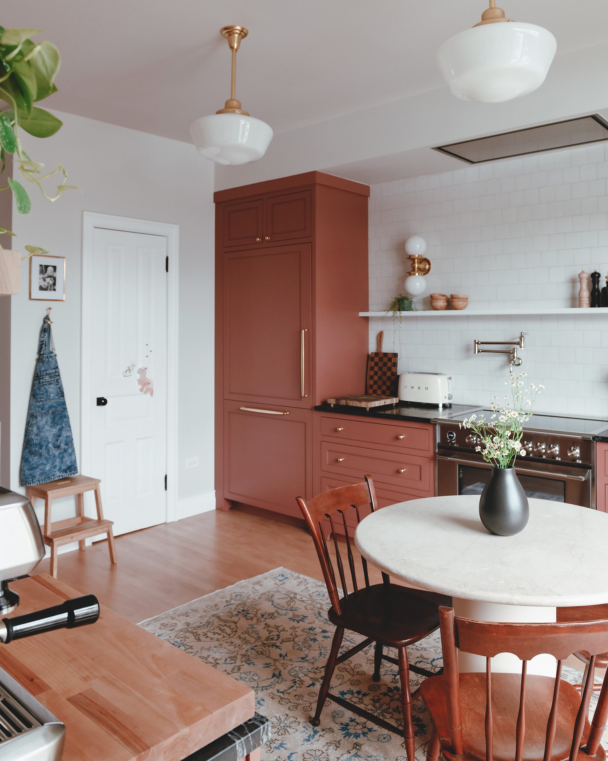 our small eat-in kitchen table with red cabinets in the background | via Yellow Brick Home