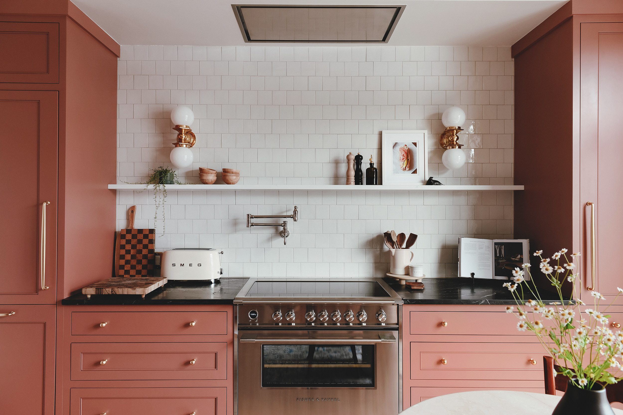 The range wall in our newly renovated kitchen featuring an induction range, colorful cabinets and a ceiling-mounted range hood // via Yellow Brick Home