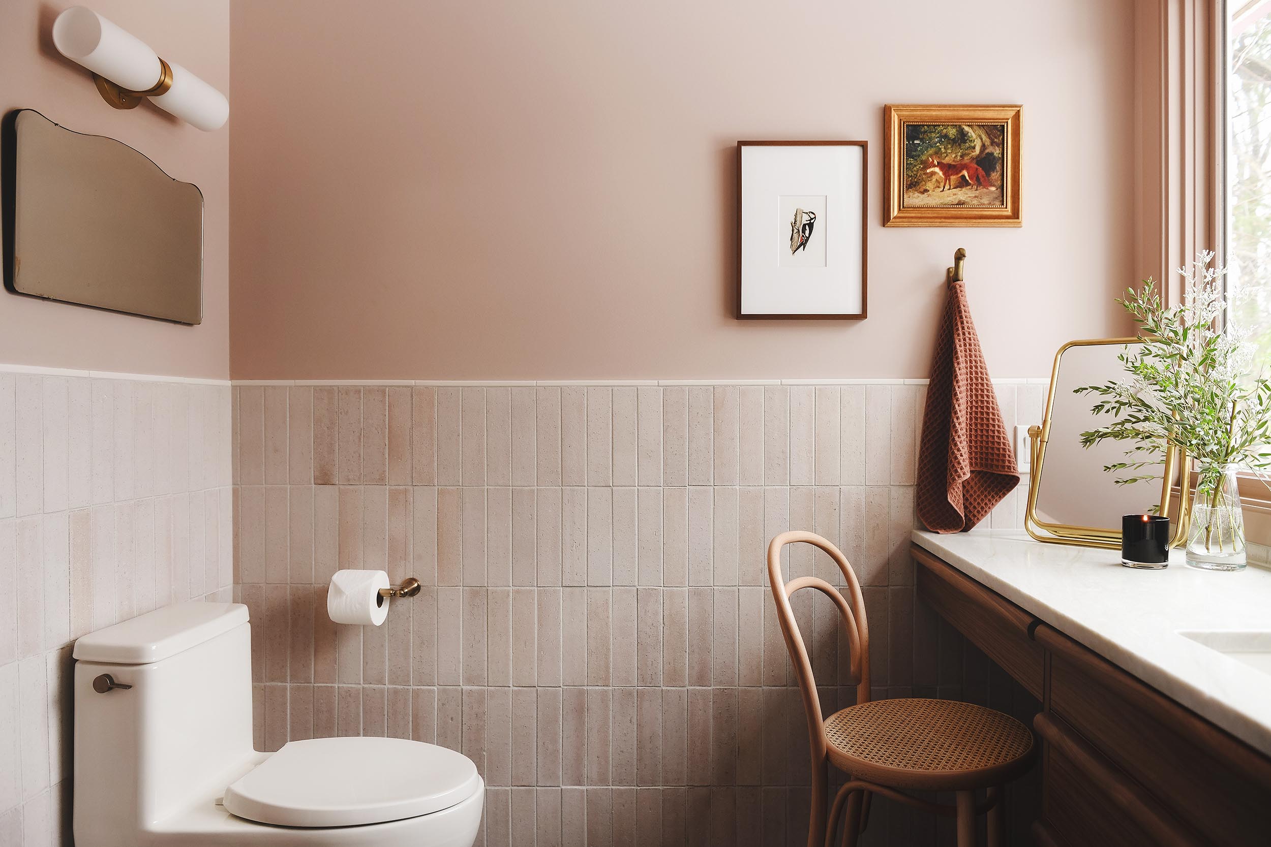 pink bathroom with wall tile, biscuit toilet, bentwood chair | via Yellow Brick Home