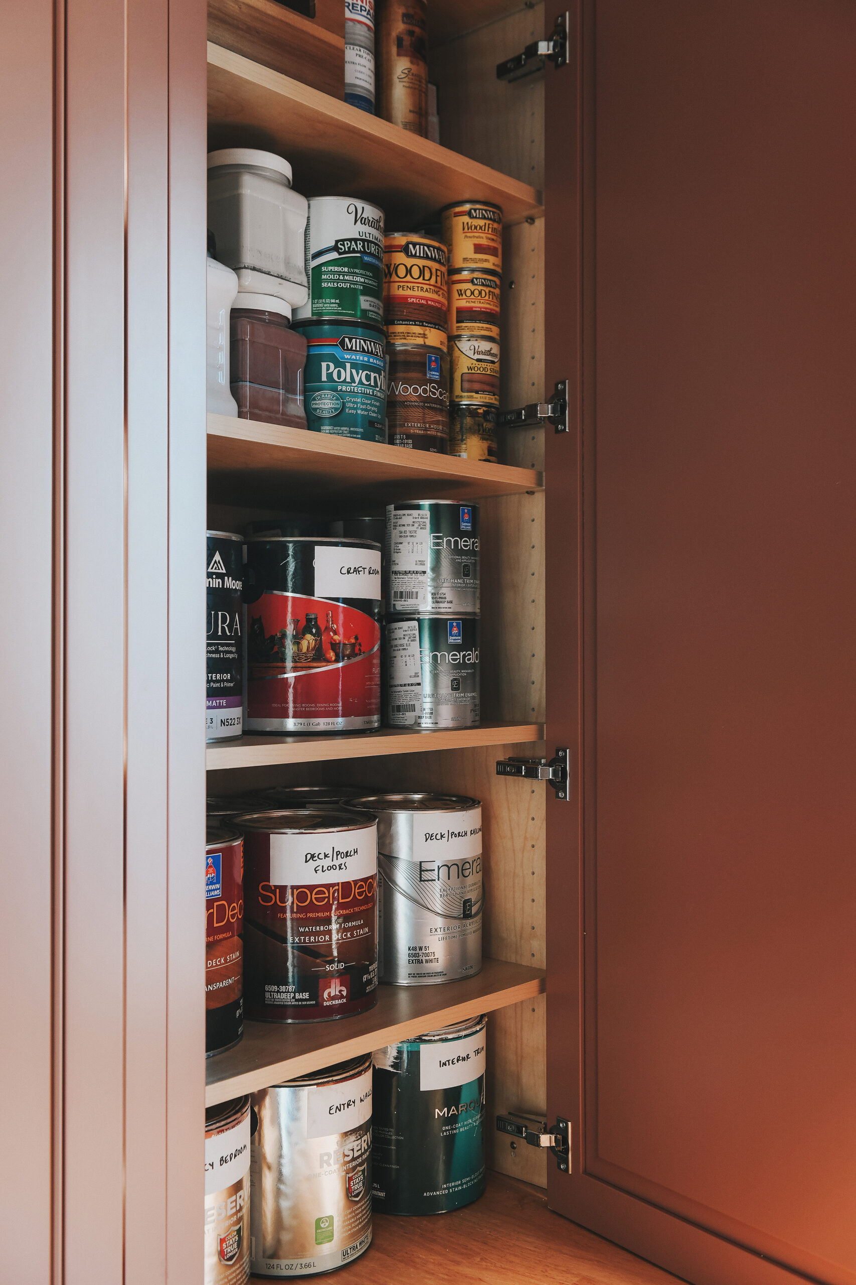 The left countertop cabinet full of paint and liquids // via Yellow Brick Home