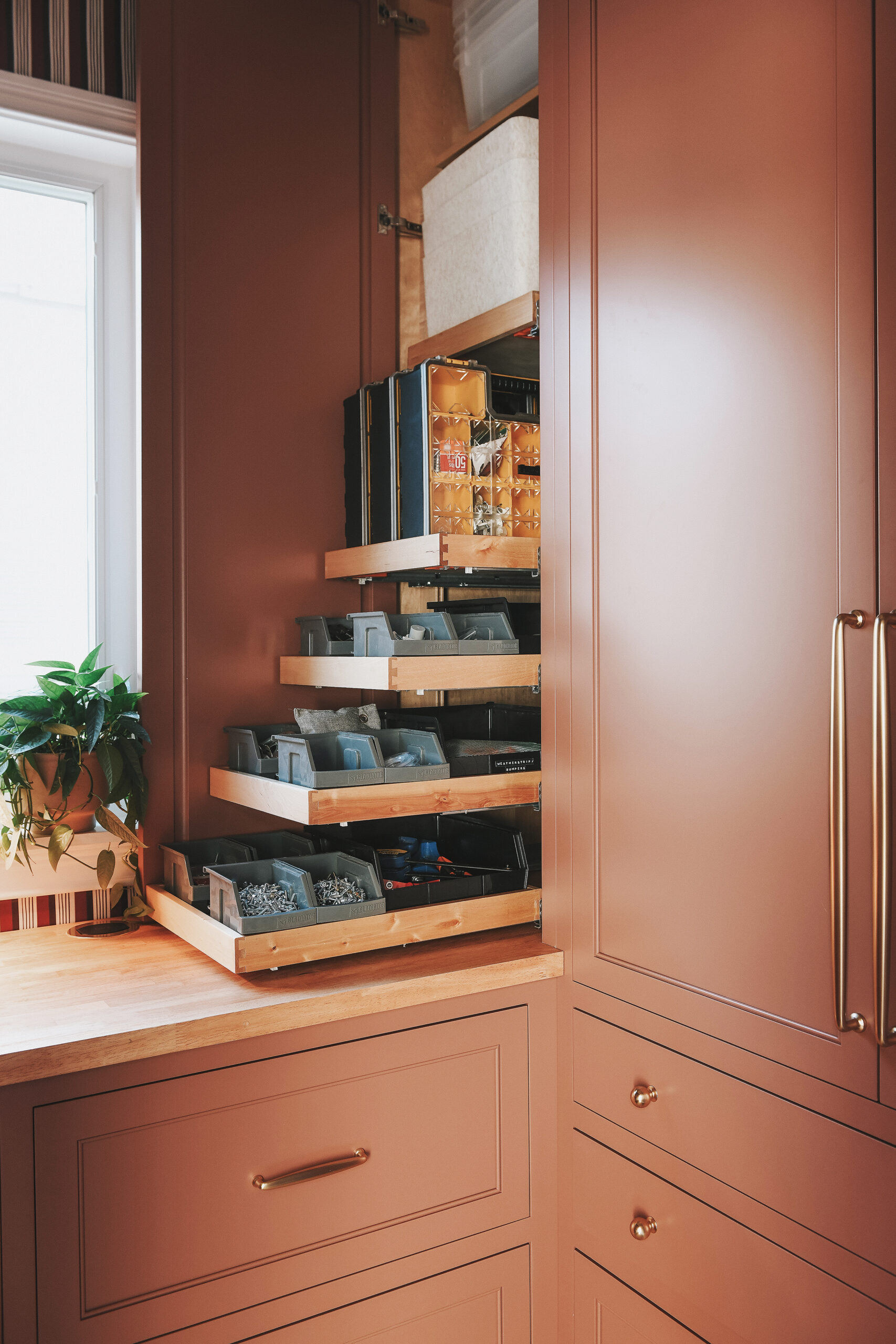 The right countertop cabinet, featuring pull-out trays full of fasteners and spare parts // via Yellow Brick Home