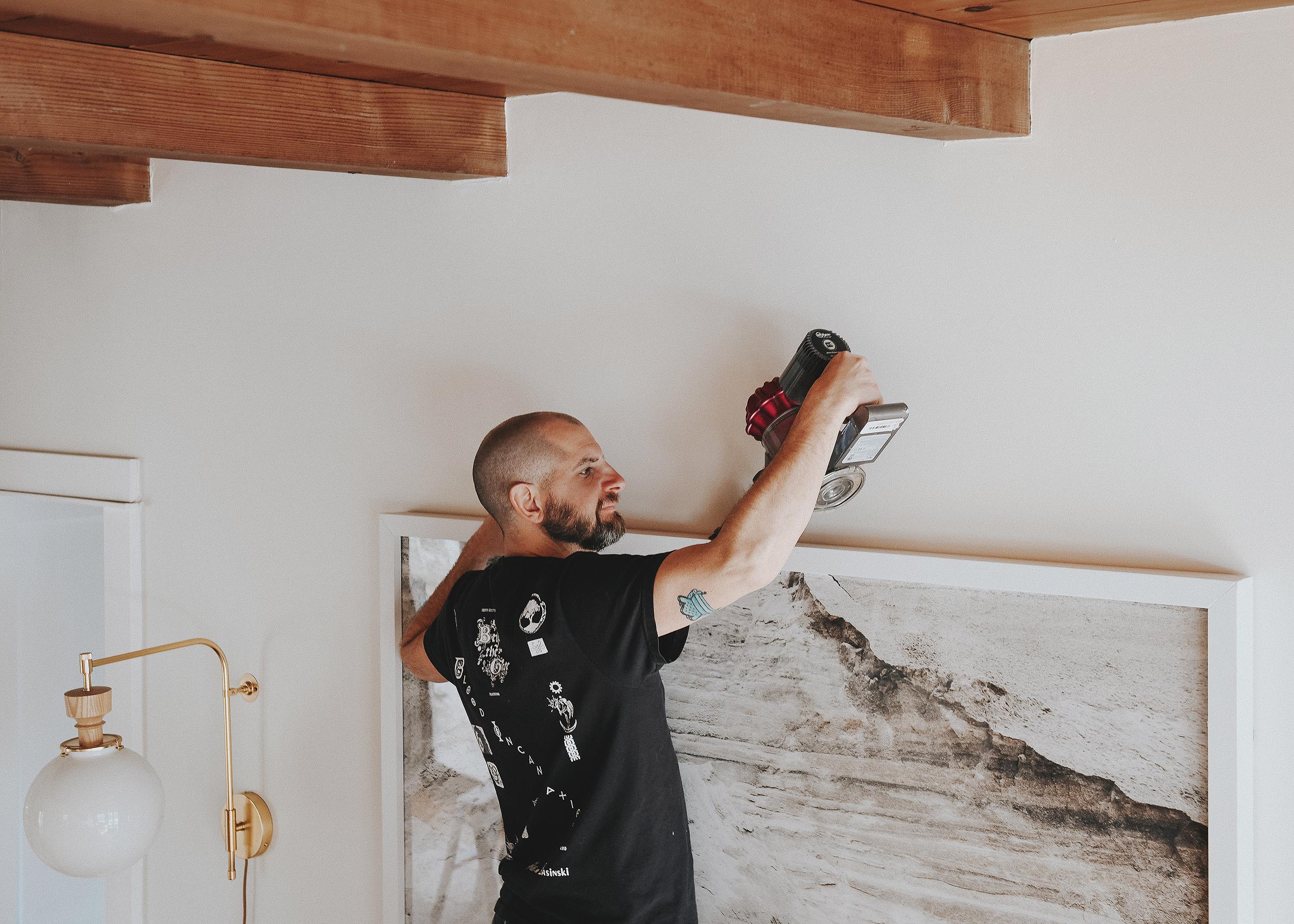 Scott cleans the top of artwork at our Michigan Tree House // via Yellow Brick Home